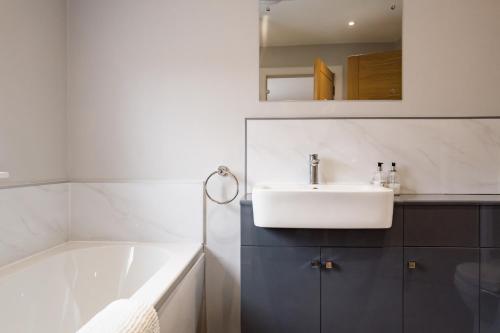 a bathroom with a sink and a bath tub at Anne's Place in Boat of Garten