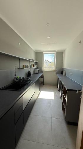 a large kitchen with black counters and a window at Hostel54 in Nürnberg