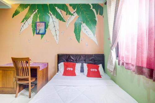 a bedroom with a bed with two red pillows at Hotel O Tebet Near Tebet Station Formerly Sabda Guest House in Jakarta