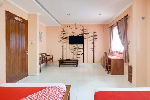 a room with two beds and a television in it at Hotel O Tebet Near Tebet Station Formerly Sabda Guest House in Jakarta
