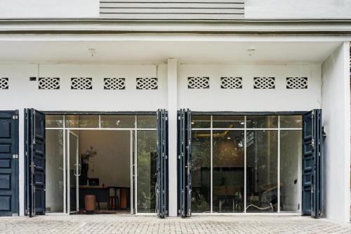 an entrance to a white building with sliding glass doors at Collection O Almasarra Residence Near Ring Road Medan in Medan