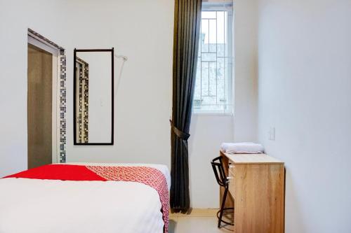a bedroom with a bed and a window at Collection O Almasarra Residence Near Ring Road Medan in Medan