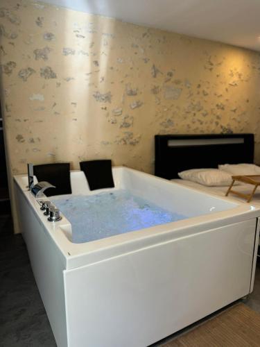 - une baignoire dans une chambre avec un lit dans l'établissement Love Queen SPA DÉTENTE, à Blois