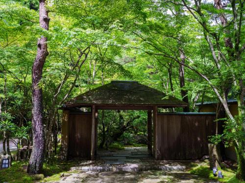 a wooden archway in the middle of a forest at 旅亭 半水盧 in Unzen