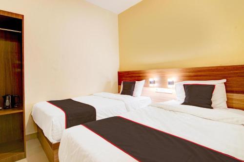 a hotel room with two beds in a room at Capital O Pusat Kota Pekanbaru Near Mall Living World Formerly Radja Homestay in Pekanbaru