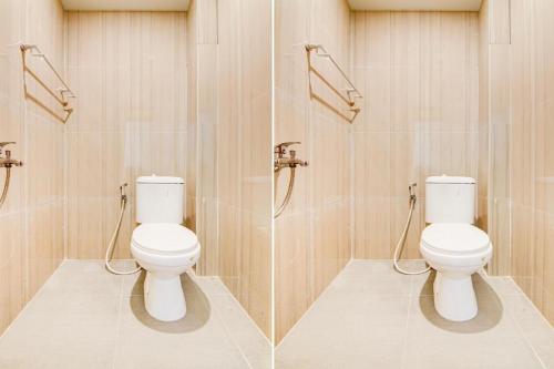 two toilets in a bathroom with wooden walls at Capital O Pusat Kota Pekanbaru Near Mall Living World Formerly Radja Homestay in Pekanbaru