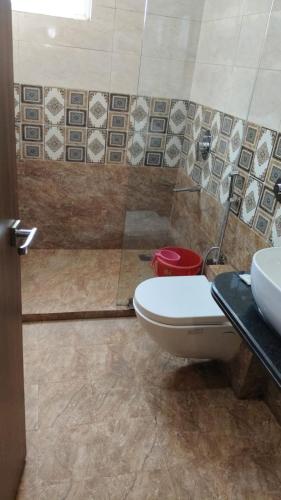 a bathroom with a toilet and a sink at Hotel The Grand by Nexottel in Robertsganj