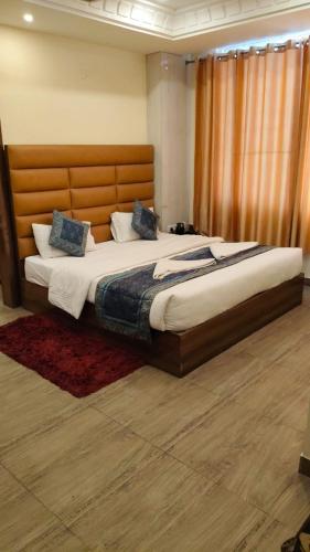 a bedroom with a large bed with a wooden headboard at Hotel The Grand by Nexottel in Robertsganj