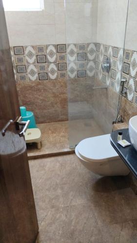 a bathroom with a toilet and a sink and a shower at Hotel The Grand by Nexottel in Robertsganj