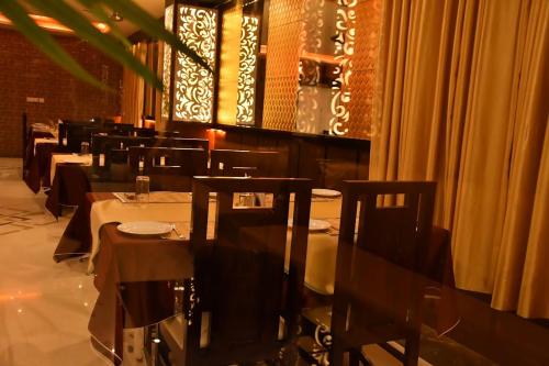 a dining room with tables and chairs in a restaurant at Hotel The Grand by Nexottel in Robertsganj