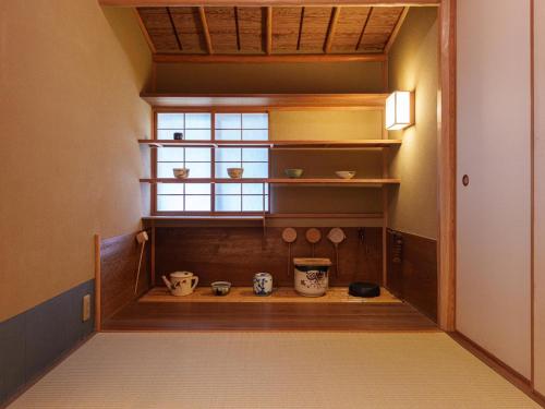 a room with a window and some bowls on shelves at 旅亭 半水盧 in Unzen