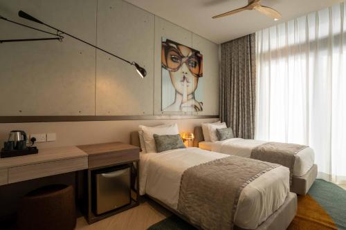 a bedroom with two beds and a desk and a painting at SeSaya Poshtel & Bistro - Colombo's Newest and Finest Poshtel Dorms and Rooms in Colombo