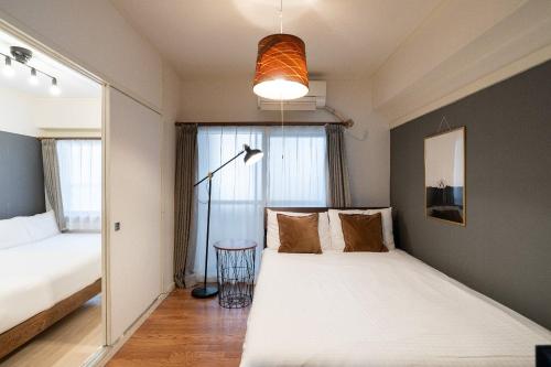 a bedroom with two beds and a window at Tsukimura Building in Tokyo