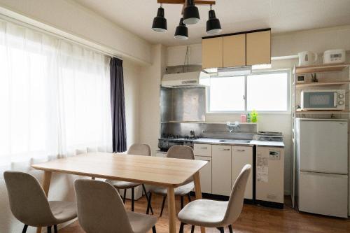 a kitchen with a wooden table and chairs in a kitchen at Tsukimura Building in Tokyo