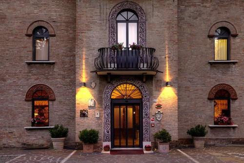 a brick building with a balcony and a door at Hotel Castello in Modena