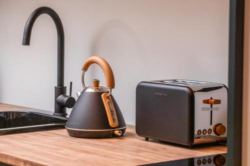 a tea kettle on a counter next to a toaster at El Palacio by Standby in Soria