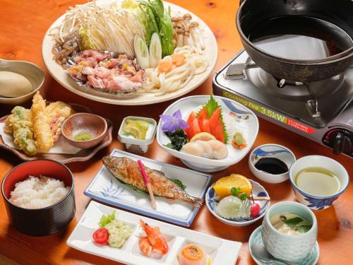 a table topped with plates of food and bowls of food at 国民宿舎古岩屋荘 in Higashi-komi