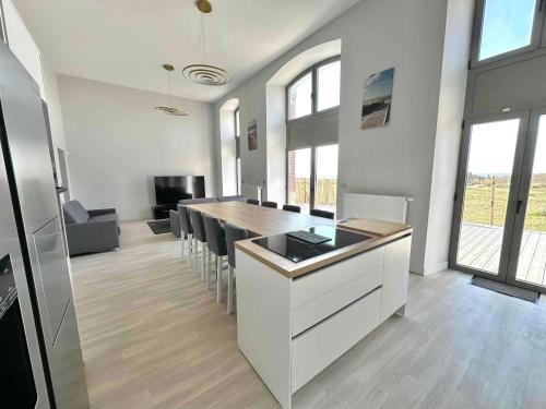 a kitchen and dining room with a table and chairs at Vue Mer avec Terrasse sur la plage de Berck et 2 Places de Parking in Berck-sur-Mer