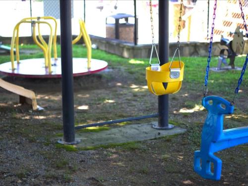 a playground with two swings and a play equipment at Cozy 1BR Mountain Retreat in Pigeon Forge