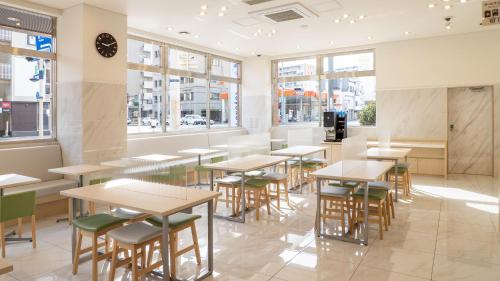 a restaurant with tables and chairs and windows at Toyoko Inn Takamatsu Ekimae in Takamatsu