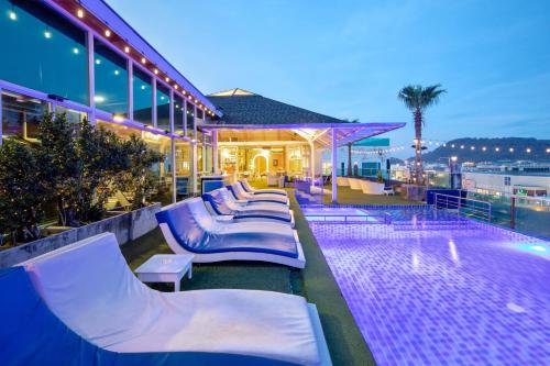 a hotel with lounge chairs and a swimming pool at Sira Grande Hotel, Patong in Patong Beach