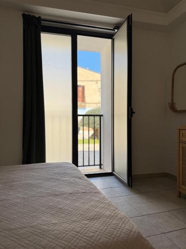 a bedroom with a bed and a sliding glass door at SottoAlCampanile in Campomarino