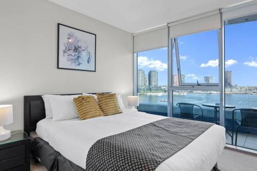 a bedroom with a large bed and a large window at Harbourfront Urban Oasis in Melbourne