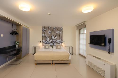 a bedroom with a bed and a flat screen tv at Vadkert Major in Sárvár