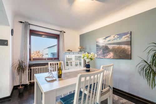 a dining room with a table and chairs and a window at Ferienhaus Am Nord-Ostsee-Kanal in Oldenbüttel