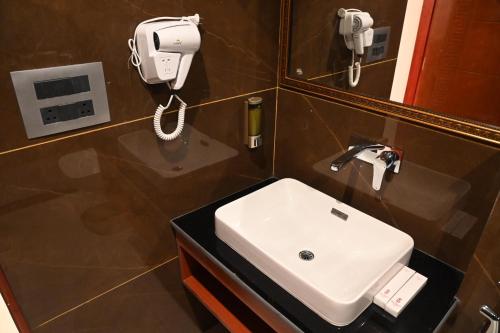 a bathroom with a sink and a phone on the wall at Hotel The Haven - Centrally Heated and Air Conditioned in Kargil
