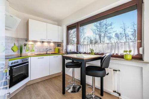 a kitchen with a table and chairs and a window at Ferienhaus Am Nord-Ostsee-Kanal in Oldenbüttel