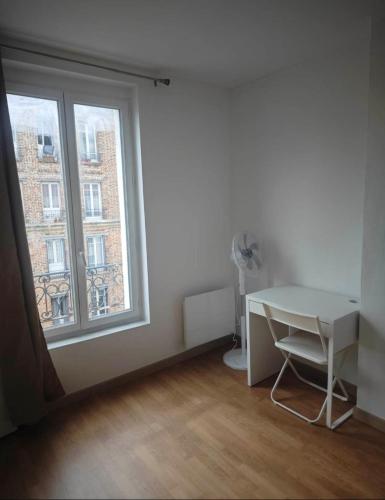 Cette chambre blanche dispose d'un bureau et d'une fenêtre. dans l'établissement Séjour en ville, à Aubervilliers