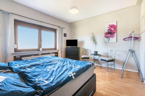 a bedroom with a bed with a blue blanket at Ferienhaus Am Nord-Ostsee-Kanal in Oldenbüttel