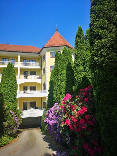 a building with a bunch of bushes and flowers at Wellnesshotel Parkschlössl zu Thyrnau Ihr adults only SPA Resort in Thyrnau