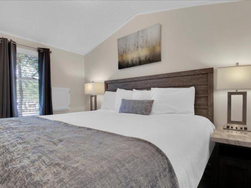 a bedroom with a large white bed and a window at Lovely 2BR Model Home in the Smokies in Pigeon Forge