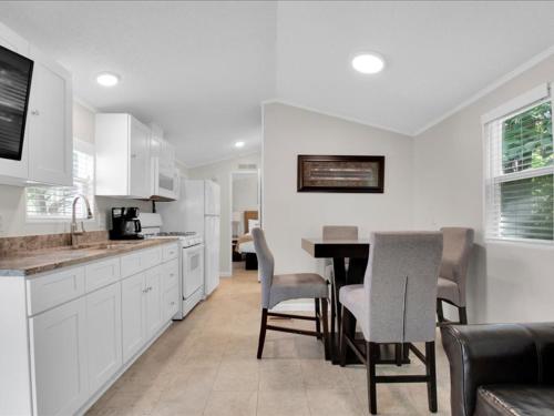 a kitchen with white cabinets and a table and chairs at Lovely 2BR Model Home in the Smokies in Pigeon Forge