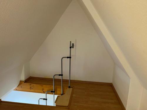 Cette chambre mansardée est dotée d'un plafond blanc et de parquet. dans l'établissement Ferienwohnung Tonne 1, à Eckernförde