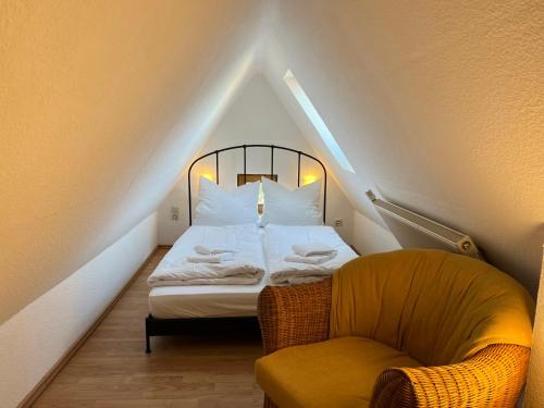 une petite chambre avec un lit et une chaise dans l'établissement Ferienwohnung Tonne 1, à Eckernförde