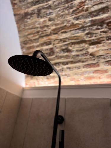 a black lamp sitting in front of a stone wall at SottoAlCampanile in Campomarino