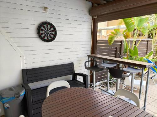 a dart board on the wall of a porch with a table and chairs at Villa Casa Palmera in Paralimni