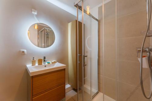 une salle de bain avec une douche, un lavabo et un miroir dans l'établissement L’Oasis Normande - Centre-ville de Rouen, à Rouen