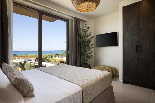 a bedroom with a bed and a view of the ocean at Villa Aya - Coastal Villa, Minimalist Elegance by etouri in Stavromenos