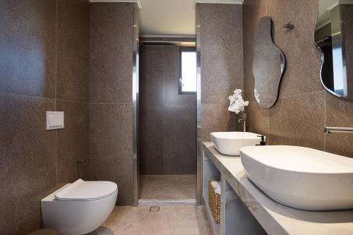 a bathroom with a toilet and a sink at Villa Aya - Coastal Villa, Minimalist Elegance by etouri in Stavromenos