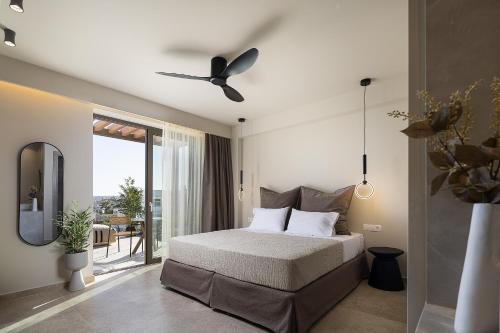 a bedroom with a bed and a ceiling fan at Villa Aya - Coastal Villa, Minimalist Elegance by etouri in Stavromenos