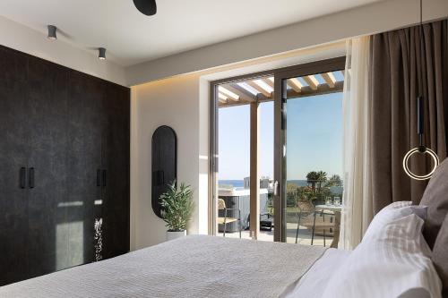 a bedroom with a bed and a view of a balcony at Villa Aya - Coastal Villa, Minimalist Elegance by etouri in Stavromenos