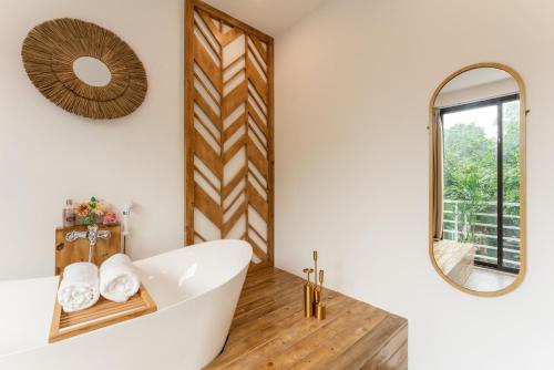 uma casa de banho com uma banheira branca e um espelho. em Homestay CHẤT- Train Street,Self check em Hanói