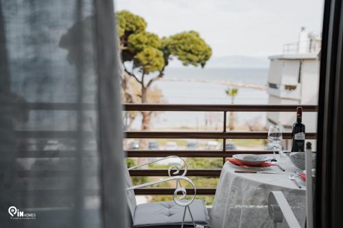 a table with a bottle of wine on a balcony at 'Nefeli' House With Amazing View Βy The Sea in Nea Makri