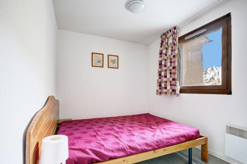 ein Schlafzimmer mit einem rosa Bett und einem Fenster in der Unterkunft L'Escapade aux Angles - Proche Stations in Les Angles