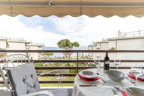 a table with wine glasses on a balcony with a view at 'Nefeli' House With Amazing View Βy The Sea in Nea Makri
