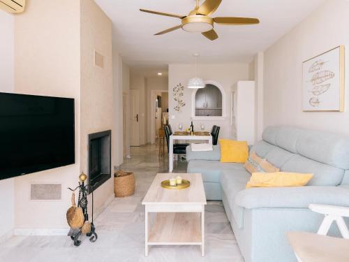 un soggiorno con un divano blu e una TV a schermo piatto di Ulises La Perla a Calahonda